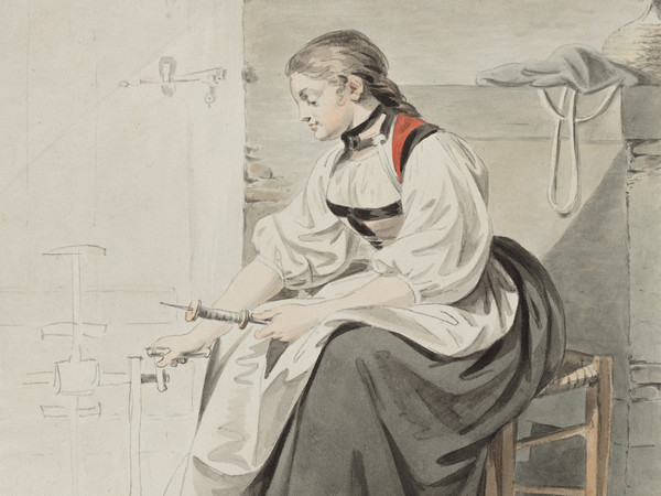 Jeune femme en costume bernois assise sur un tabouret en bois dans une pièce, devant un dévidoir
